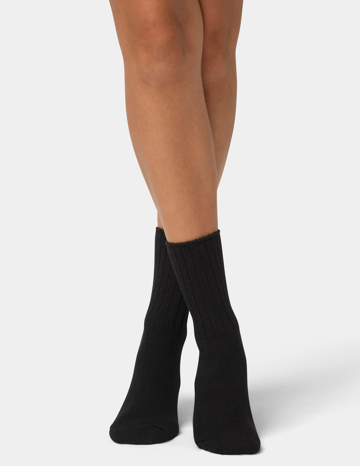 Black socks worn by a person on a white background