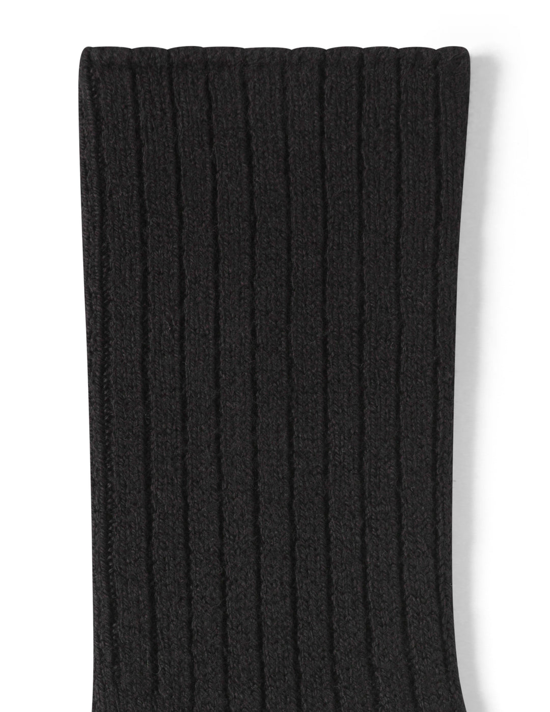 Close-up of a black ribbed knit sock on a white background