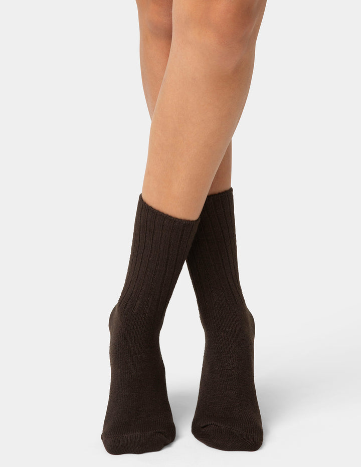 Brown socks worn by a person on a white background