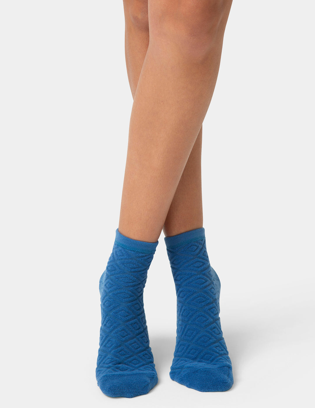 Blue textured socks worn by a person on a white background
