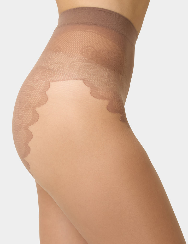 Beige sheer stockings being worn on a plain background